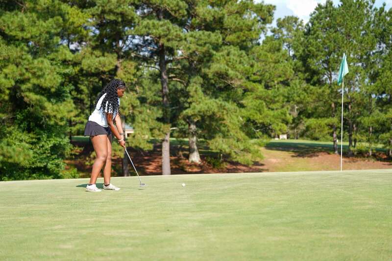 Mendenhall High School Golfer taking a swing at a golf ball.