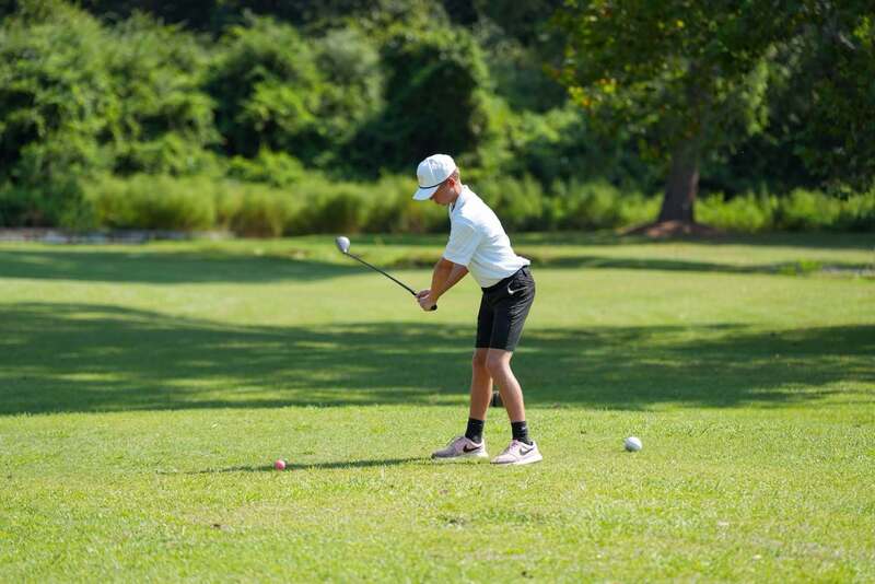 Mendenhall High School Golfer taking a swing at a golf ball.