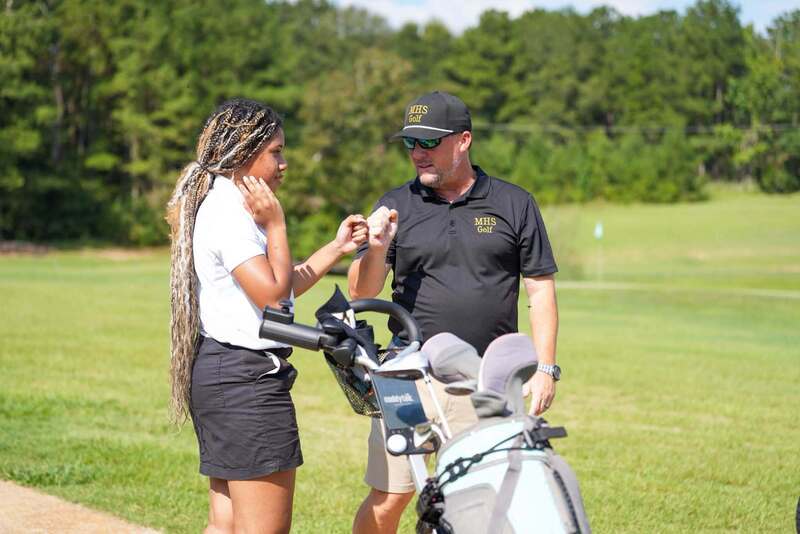 Mendenhall High School golf coach encouraging a golfer.