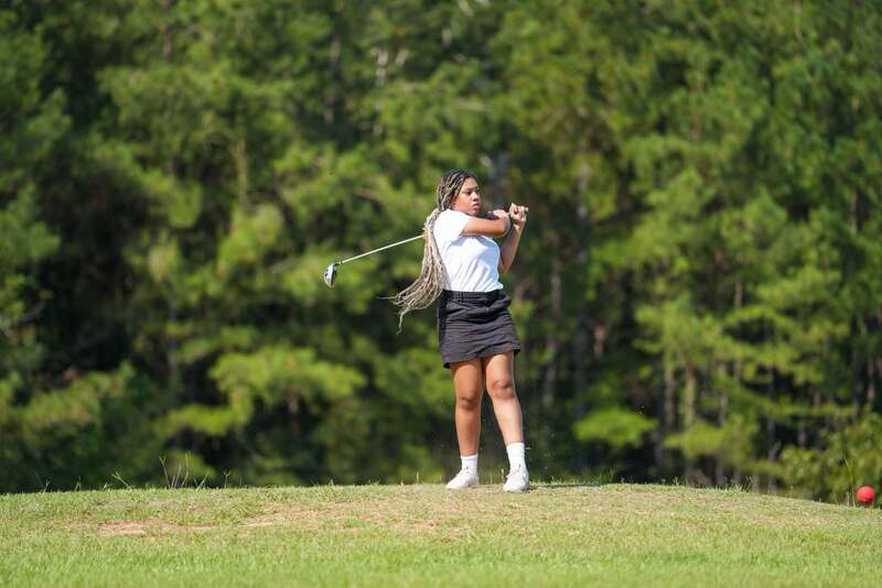 Mendenhall High School Golfer taking a swing at a golf ball.