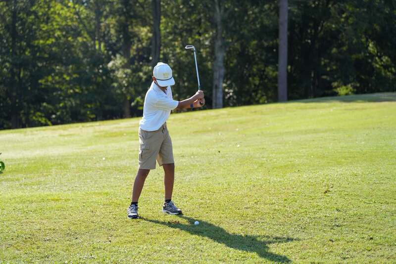 Mendenhall High School Golfer taking a swing at a golf ball.