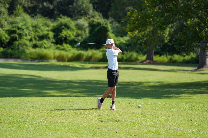 Mendenhall High School Golfer taking a swing at a golf ball.