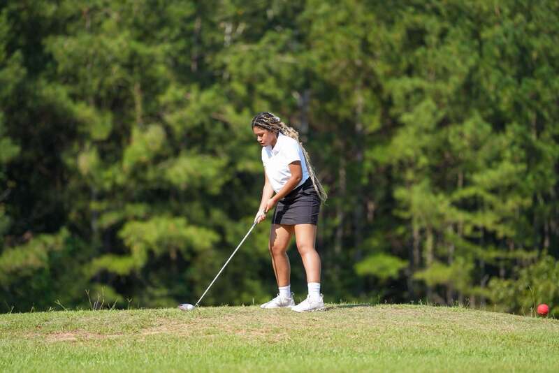 Mendenhall High School Golfer taking a swing at a golf ball.