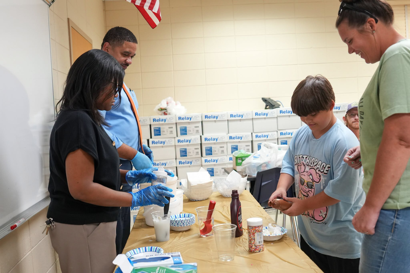 Mendenhall Elementary principals serving ice cream to a student.