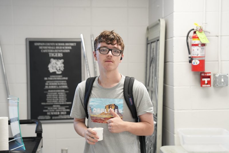 A male high school student gives a thumbs up for Moo Brew Coffee
