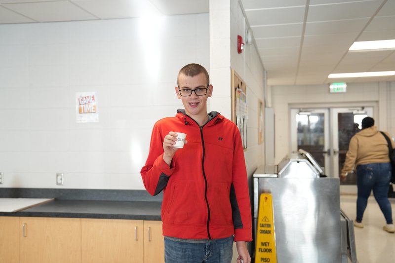 A male high school student gives a thumbs up for Moo Brew Coffee