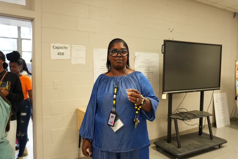 A teacher poses with a cup of Moo Brew