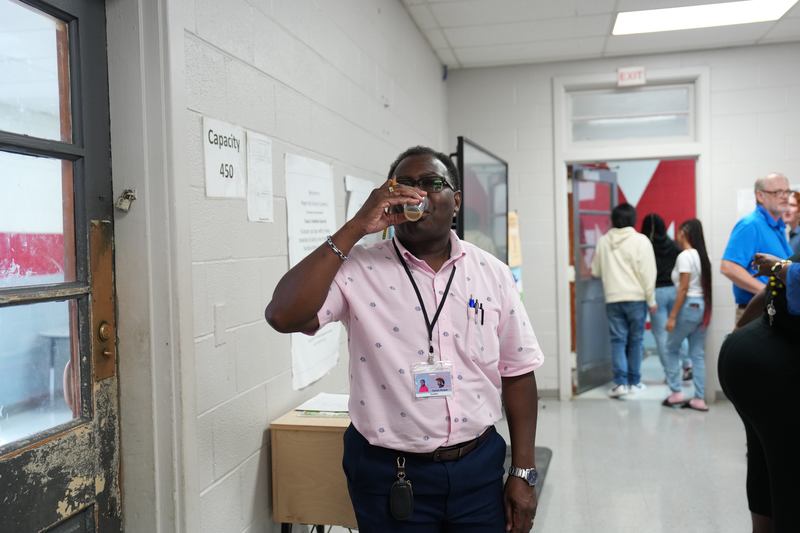 A teacher poses with a cup of Moo Brew