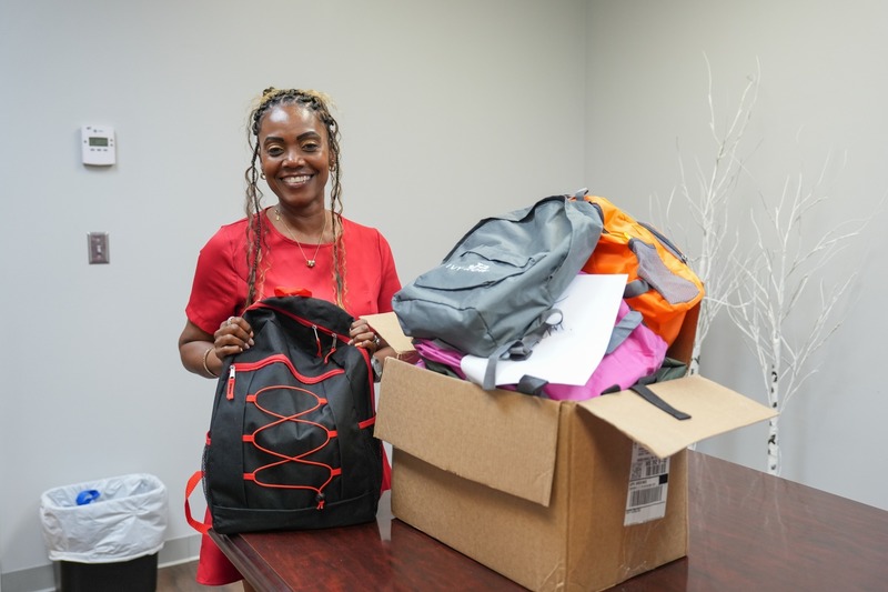 A principal poses with the donated backpacks.