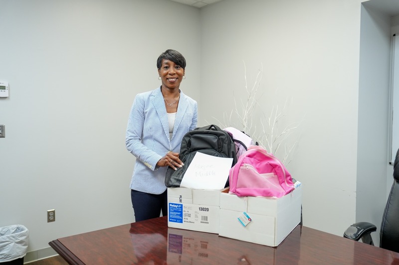 A principal poses with the donated backpacks.