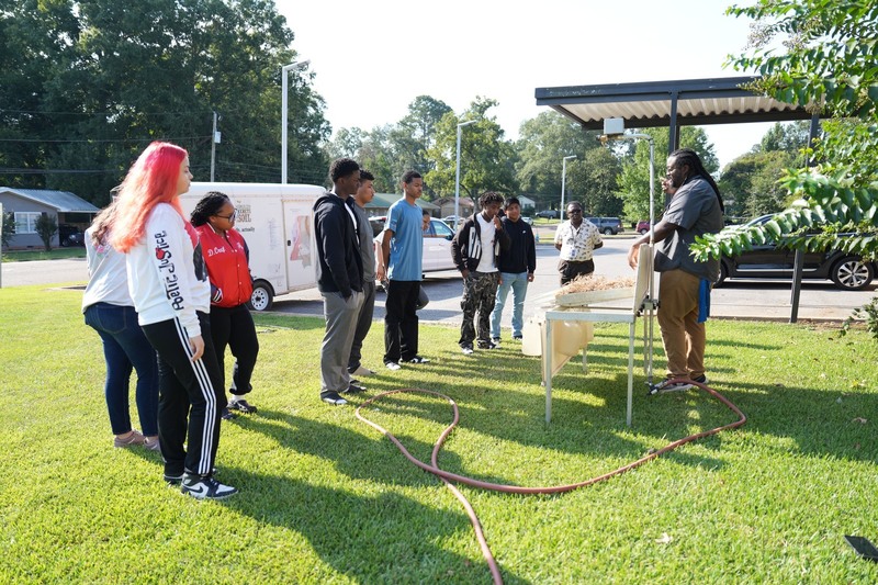 Students observe the rainfall simulator. 