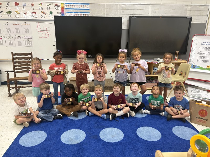 Pre-K students pose with apple pies.