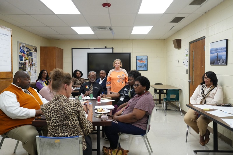 A group of educators, business and industry partners, and community members are having a discussion.
