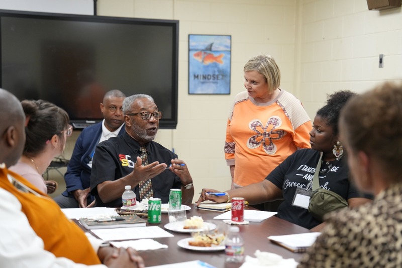 School Board President is talking to a group of people.