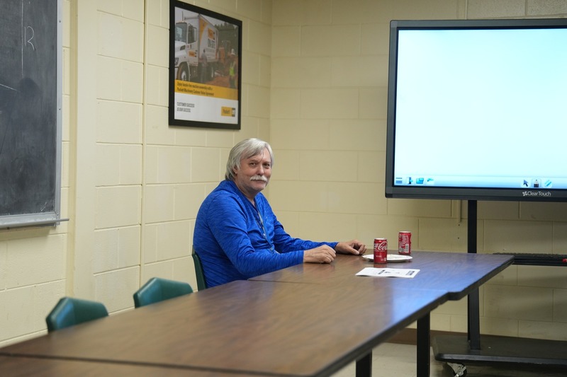 A man is sitting at a table and smiling for a photo.