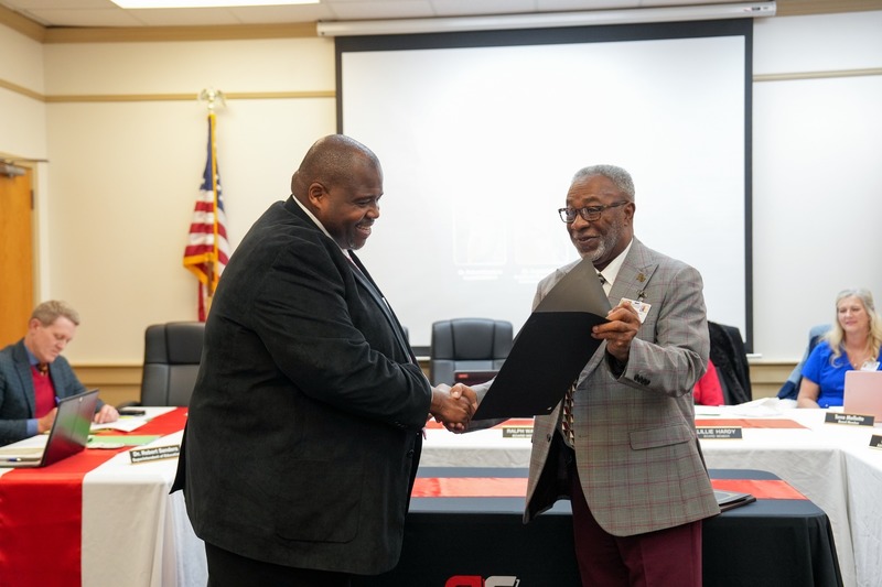 Superintendent shakes board president's hand