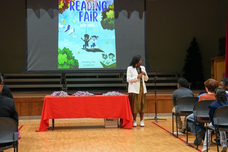 Students standing near their reading fair projects.