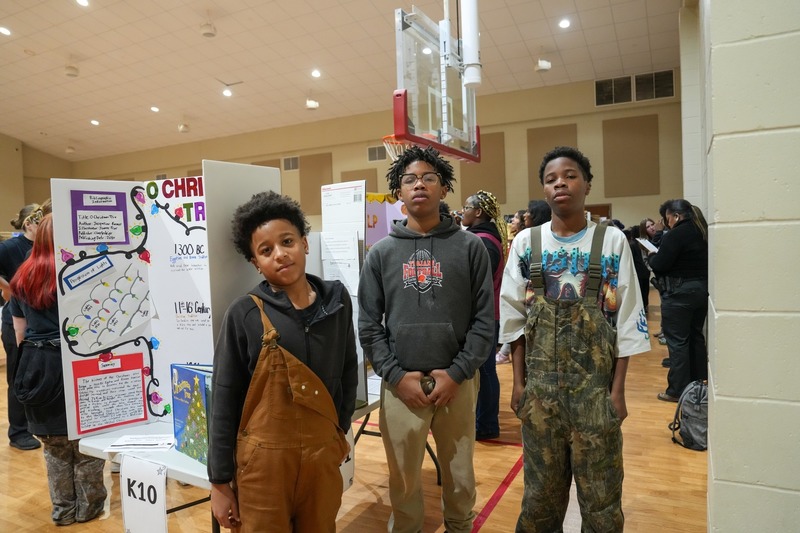Students standing near their reading fair projects.