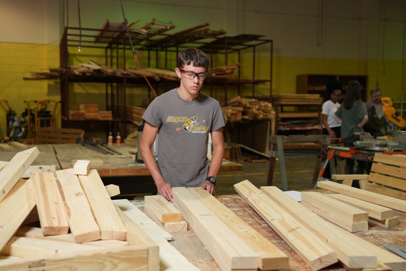 A student is organizing wood