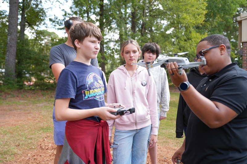 Unmanned Aircraft Systems instructor showing a drone to a group of students.