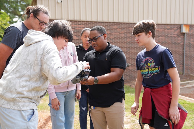 Unmanned Aircraft Systems instructor showing a drone to a group of students.