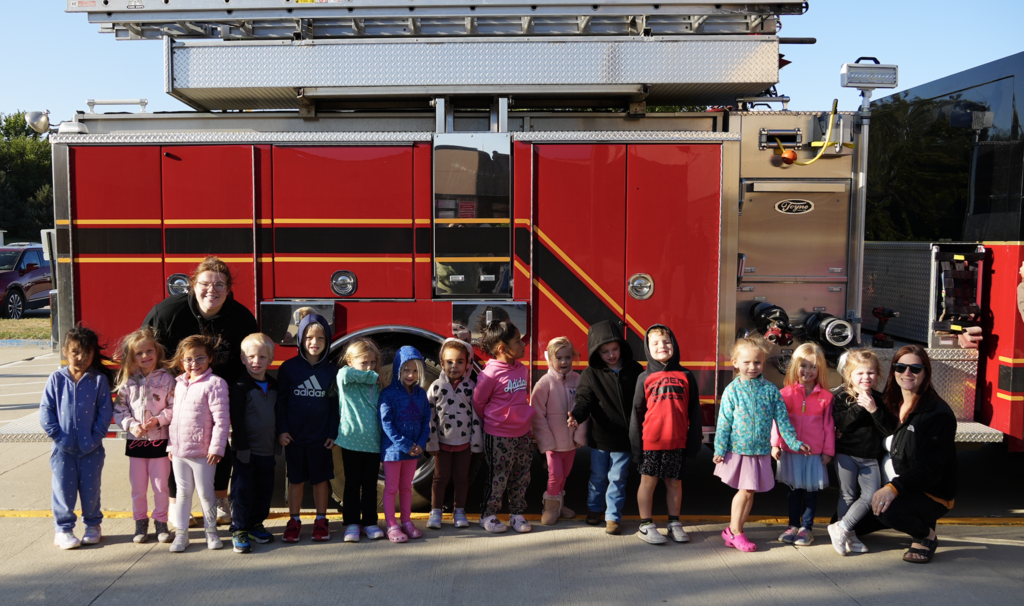 Preschool poses in front of a fire truck.
