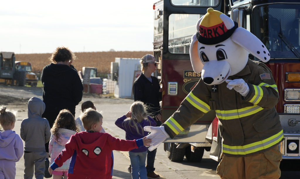 student high fives Sparky for fire prevention week