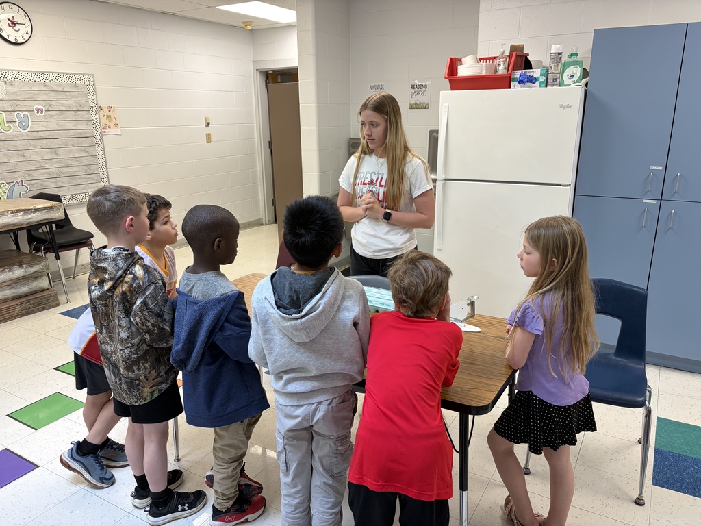 high school students working with elementary students