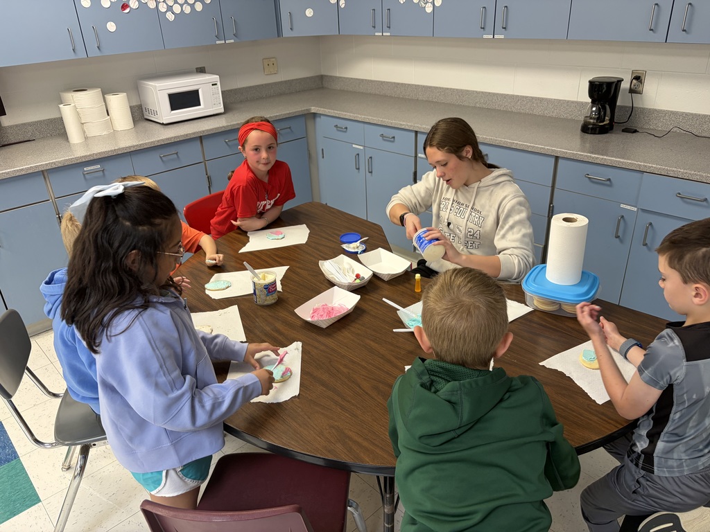 high school students working with elementary students