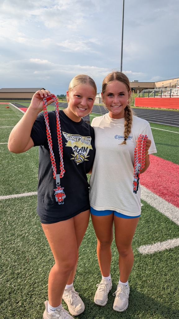 Girls on field posing with rebel chain award