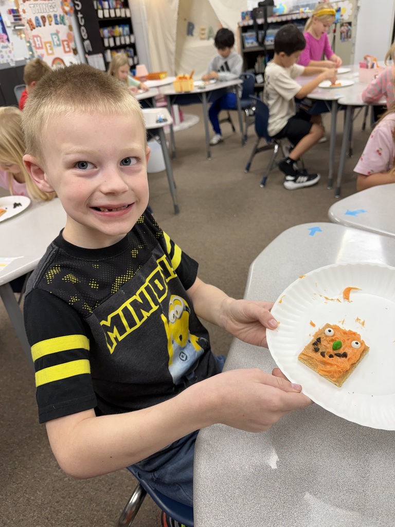 kid posing with pumpkin snack