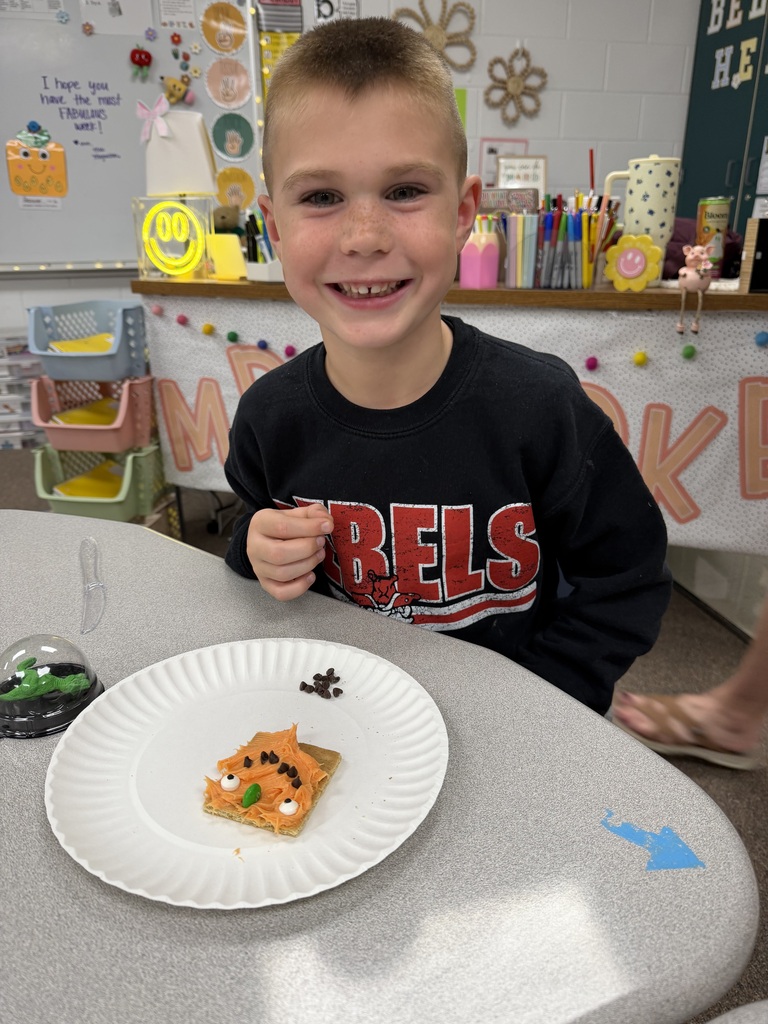 kid posing with pumpkin snack