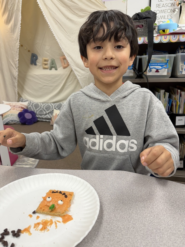 kid posing with pumpkin snack