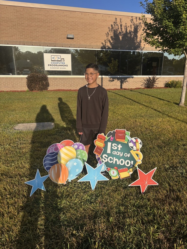 1 student posing behind a sign that says "1st day of school"