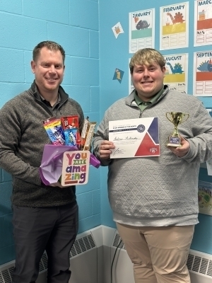 Andrew Markowsky and Preston Fischer pose together holding gifts