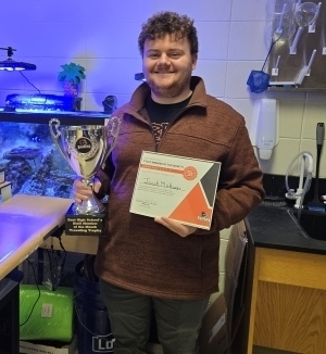 Jacob Mattoon poses with a trophy and a certificate