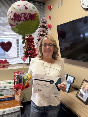 Melissa Holsinger poses with balloon and certificate