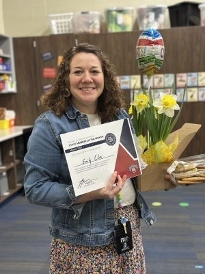 Emily Cole poses with a certificate and flowers