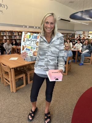 Krista Benson holds a certificate and cookies