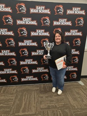 Jen Swanson poses with a certificate and trophy