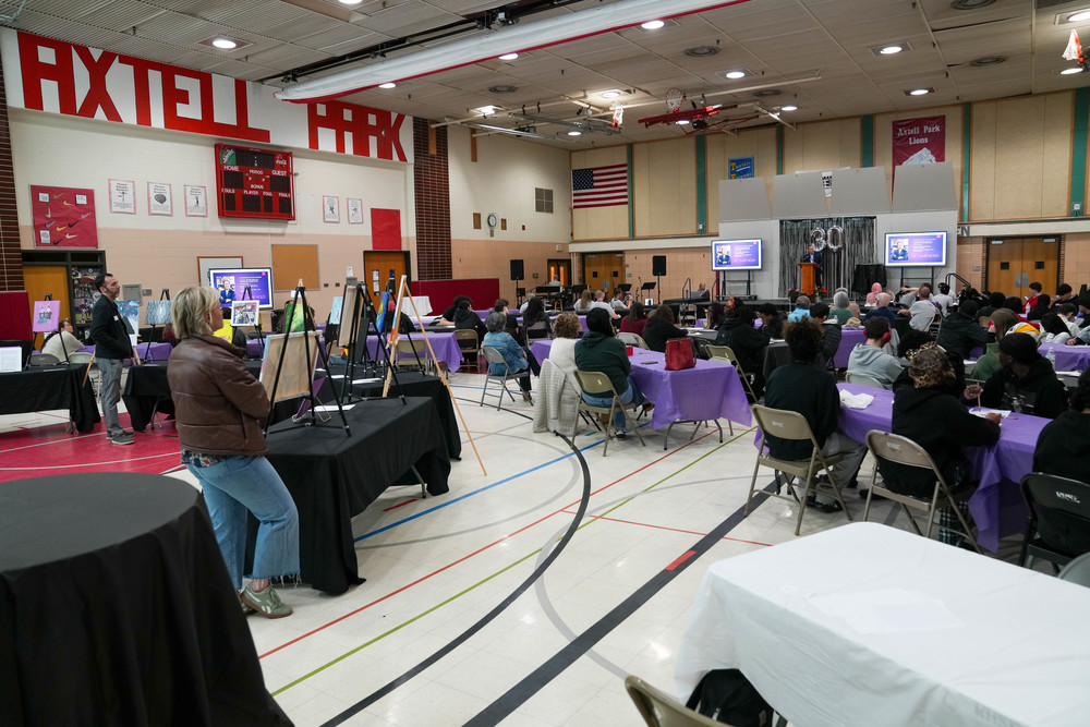 A crowd of students and staff gather in a gymnasium to listen to superintendent Dr. Jamie Nold give an address to celebrate the 30th anniversary of Joe Foss High School