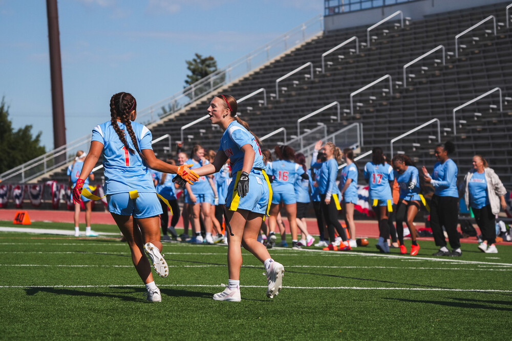 Two Lincoln High School Girls Flag Football Players slap hands after a good play at the very first Girls Flag Football Jamobree at Howard Wood Field