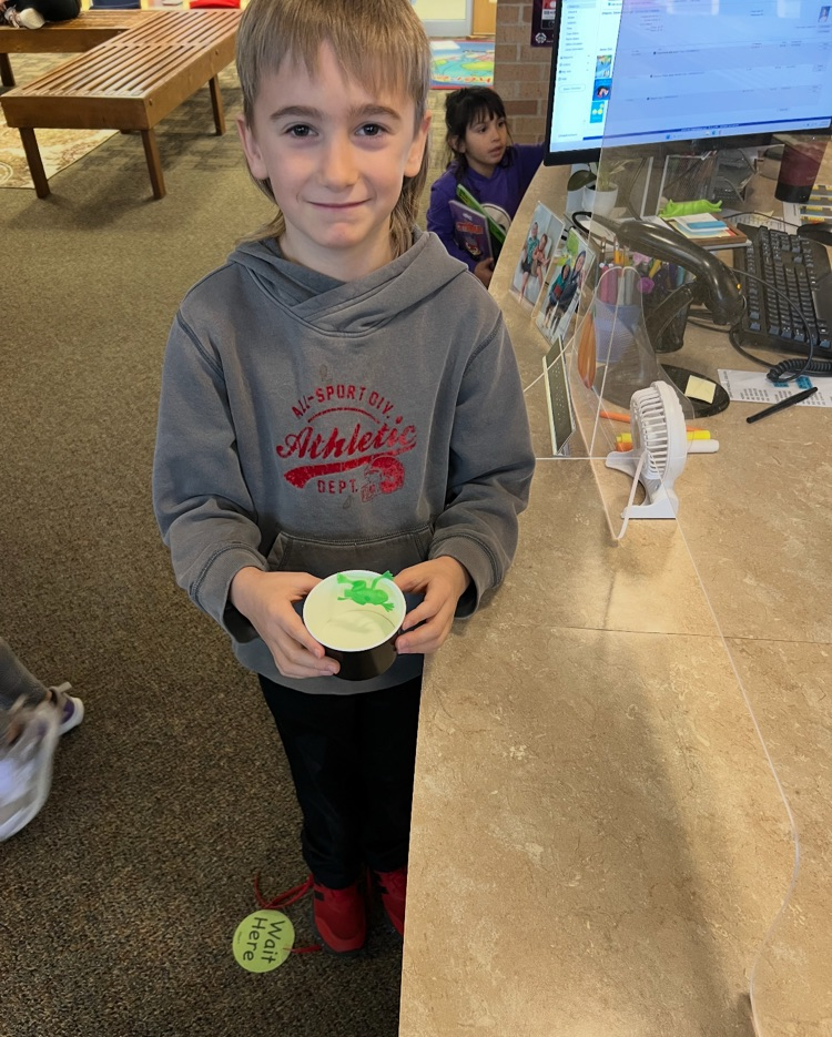 student holding a cup with a frog