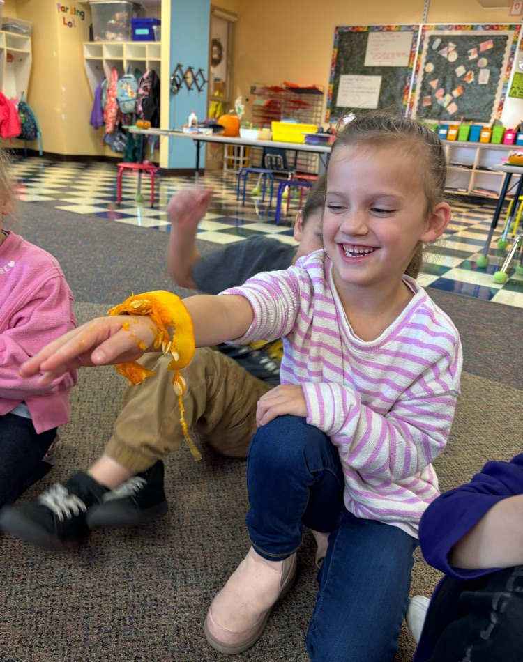 student holding the inside of a pumpkin