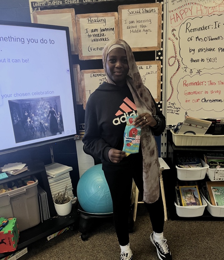 student standing in front of a board doing a social studies activity 