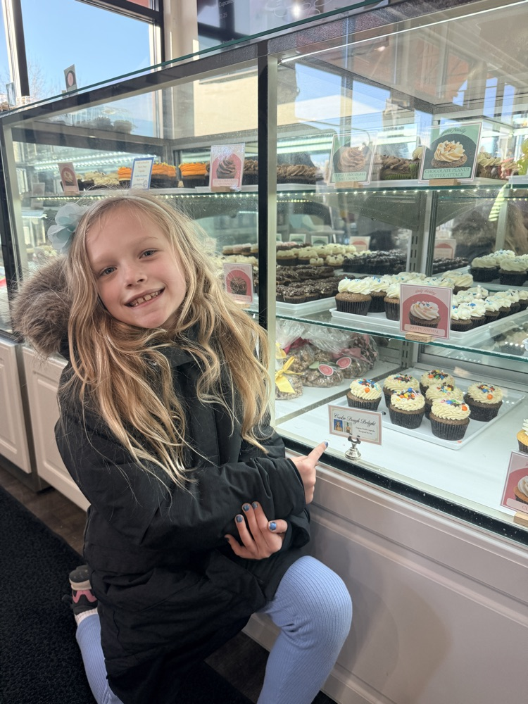 a student in front of a bakery case 