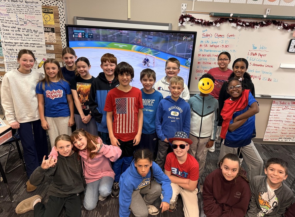 Group of students smiling and wearing red, white, and blue. 