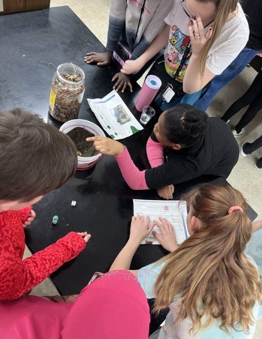 Students at Water Festival talking about soil and growing plants.