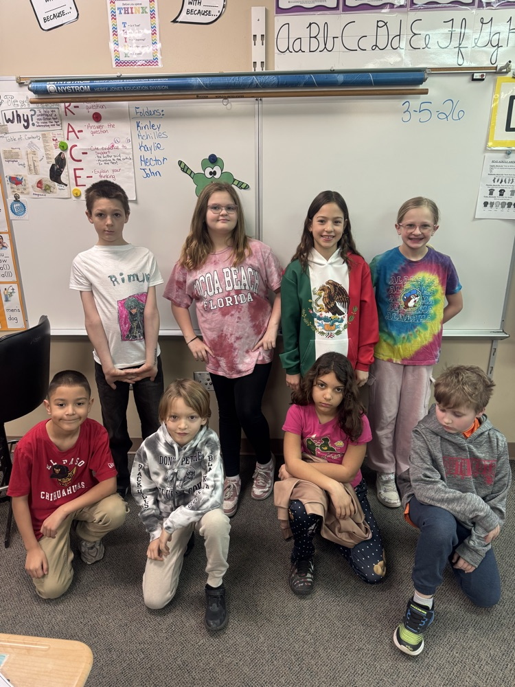 eight students showing off their travel shirts 