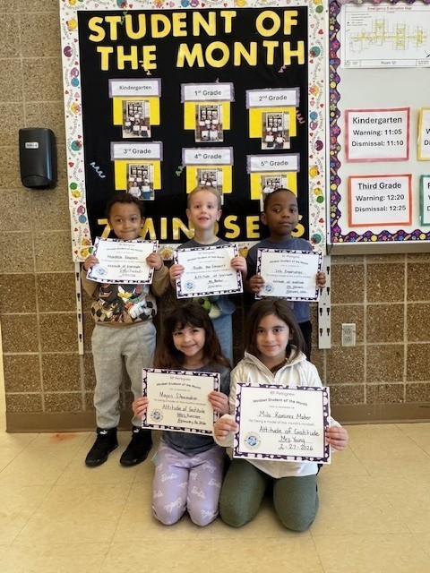 kindergarten students holding student of the month certificates